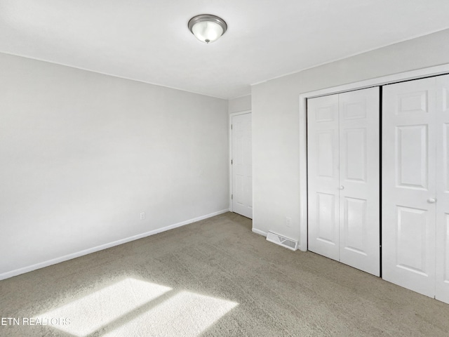 unfurnished bedroom featuring carpet and a closet