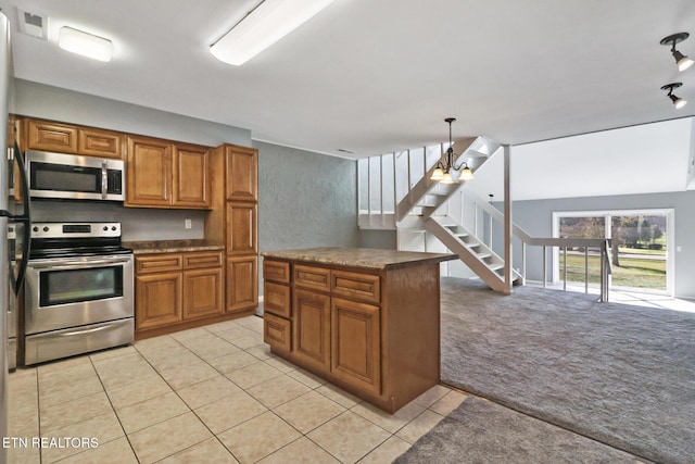 kitchen featuring light carpet, stainless steel appliances, pendant lighting, an inviting chandelier, and lofted ceiling