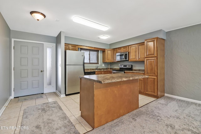 kitchen featuring sink, a kitchen island, light tile patterned flooring, and appliances with stainless steel finishes