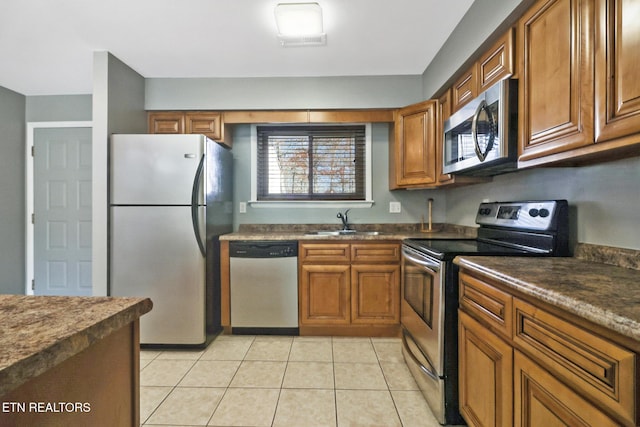 kitchen with appliances with stainless steel finishes, light tile patterned floors, and sink