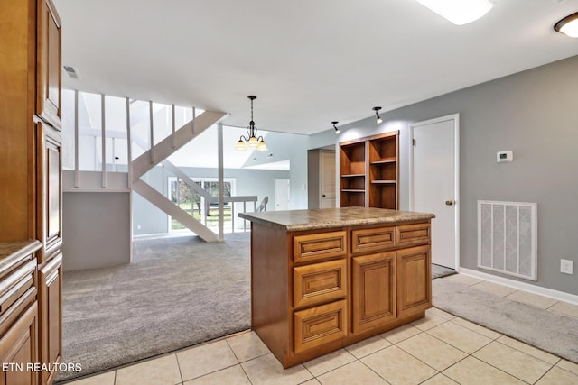 kitchen with an inviting chandelier, light colored carpet, pendant lighting, and a kitchen island