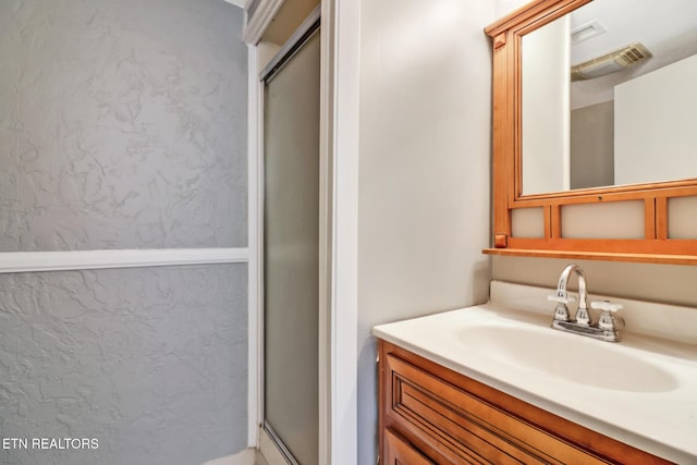 bathroom with vanity and a shower with shower door