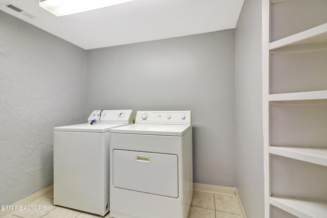 washroom featuring washer and dryer and light tile patterned floors