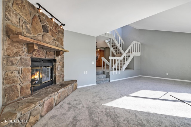 unfurnished living room featuring carpet flooring, a stone fireplace, and lofted ceiling