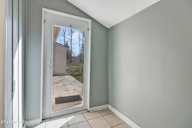 doorway to outside featuring lofted ceiling and light tile patterned floors