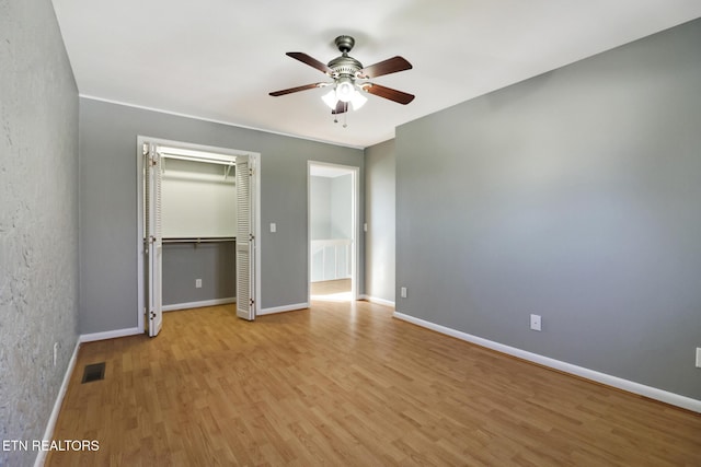 unfurnished bedroom with light hardwood / wood-style flooring, a closet, and ceiling fan