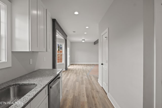 kitchen featuring light stone countertops, baseboards, recessed lighting, light wood-style floors, and dishwasher