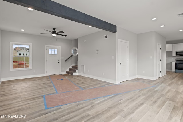 unfurnished living room featuring visible vents, beamed ceiling, light wood-type flooring, stairs, and recessed lighting