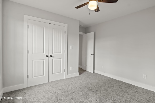 unfurnished bedroom with a closet, baseboards, ceiling fan, and carpet flooring