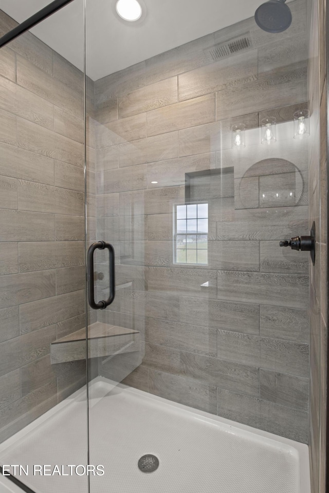 bathroom with visible vents and a shower stall