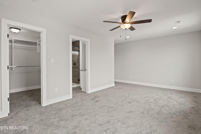 unfurnished bedroom featuring baseboards, visible vents, carpet floors, a closet, and a walk in closet