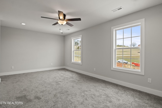 empty room with visible vents, baseboards, a ceiling fan, and carpet flooring