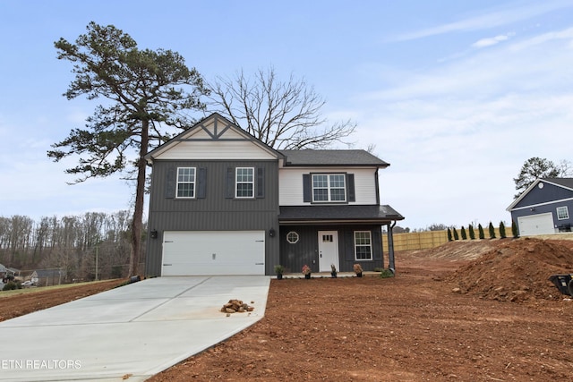 traditional-style house featuring a garage, concrete driveway, and a shingled roof