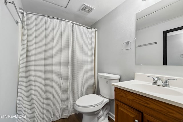 bathroom featuring a shower with shower curtain, visible vents, vanity, and toilet