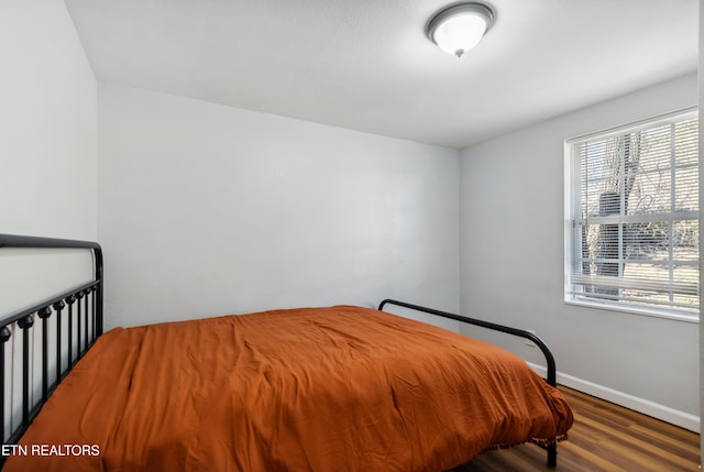 bedroom with wood finished floors and baseboards