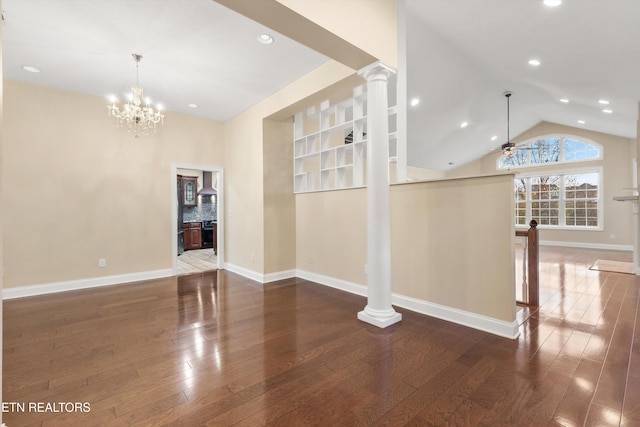 interior space featuring ceiling fan with notable chandelier, ornate columns, dark wood-type flooring, and vaulted ceiling