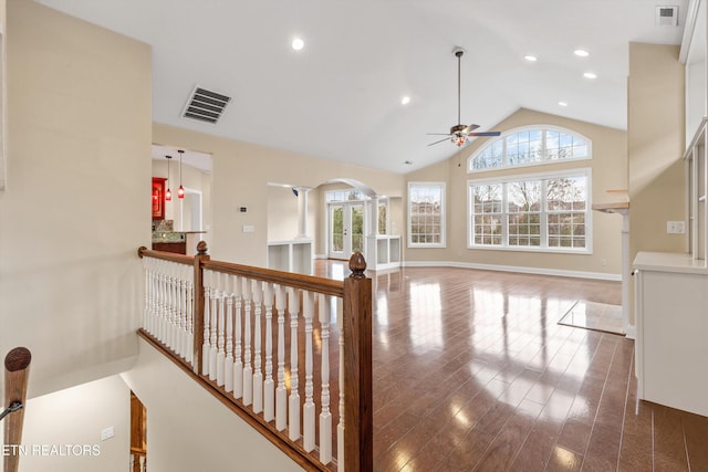 corridor with hardwood / wood-style flooring and high vaulted ceiling