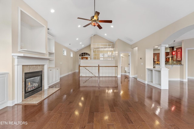 unfurnished living room featuring a fireplace, ceiling fan, dark wood-type flooring, and high vaulted ceiling