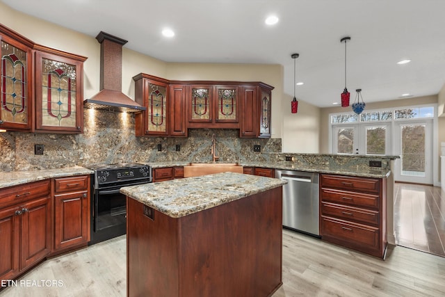 kitchen featuring black range with electric stovetop, wall chimney range hood, light hardwood / wood-style flooring, stainless steel dishwasher, and a kitchen island