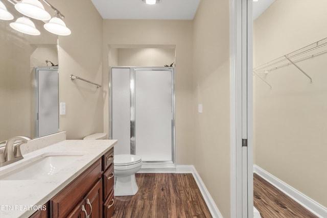 bathroom featuring hardwood / wood-style floors, vanity, and a shower with door