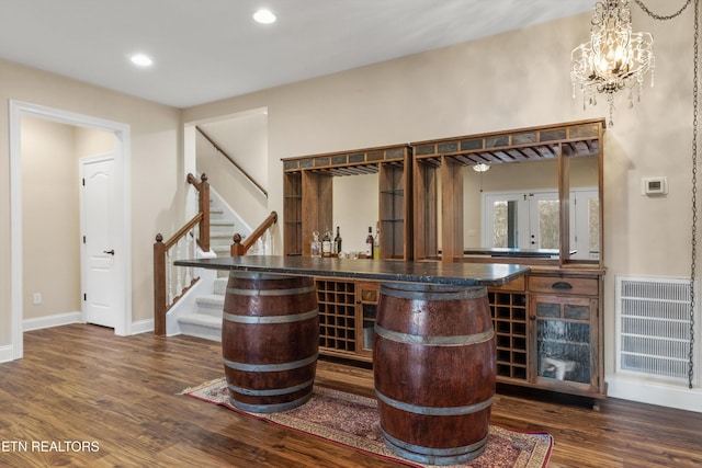 bar with french doors, dark hardwood / wood-style flooring, a chandelier, and decorative light fixtures