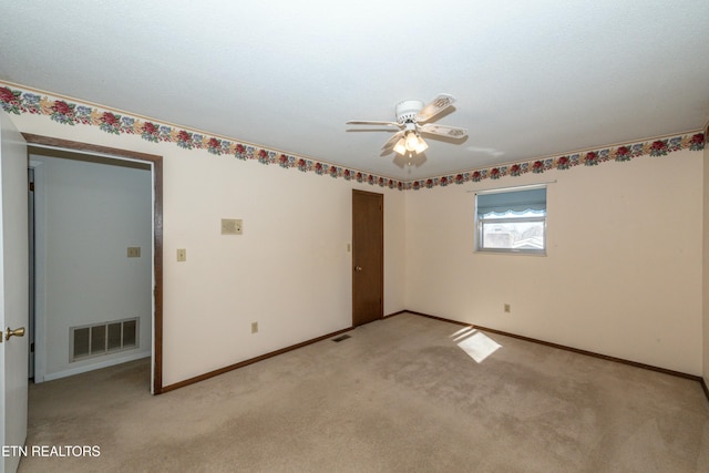 spare room featuring ceiling fan and light colored carpet