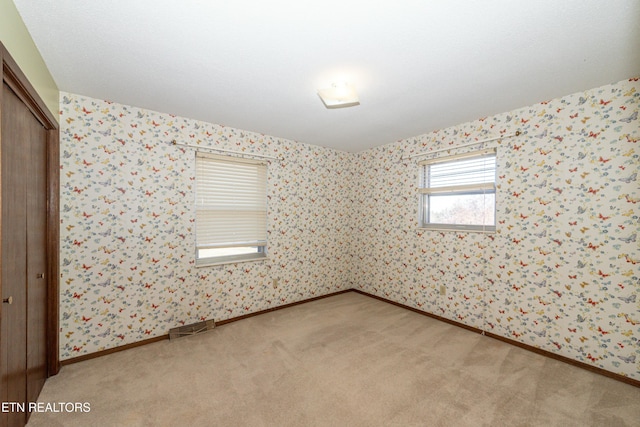 unfurnished room featuring light colored carpet