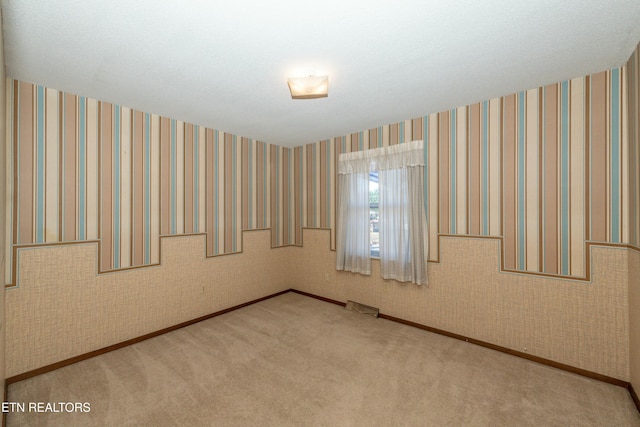 unfurnished room featuring carpet