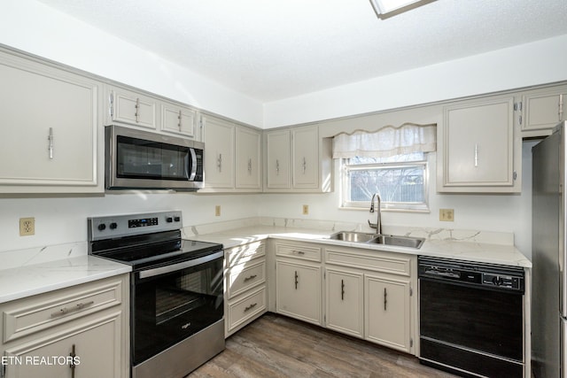 kitchen featuring gray cabinetry, sink, appliances with stainless steel finishes, and dark wood-type flooring