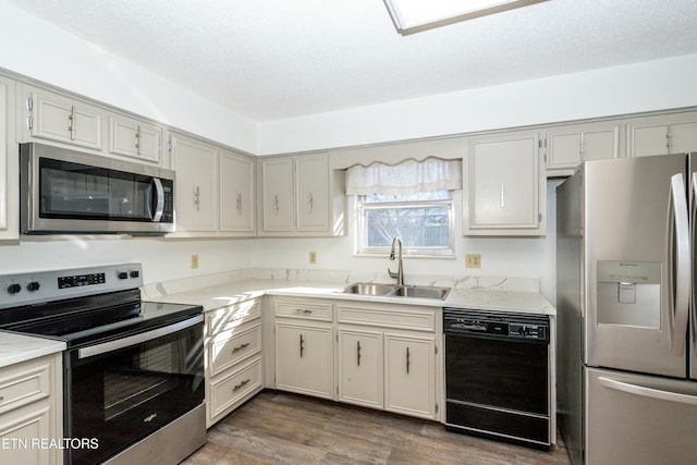 kitchen featuring a textured ceiling, dark hardwood / wood-style flooring, stainless steel appliances, and sink