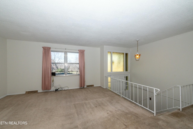 carpeted spare room featuring a textured ceiling