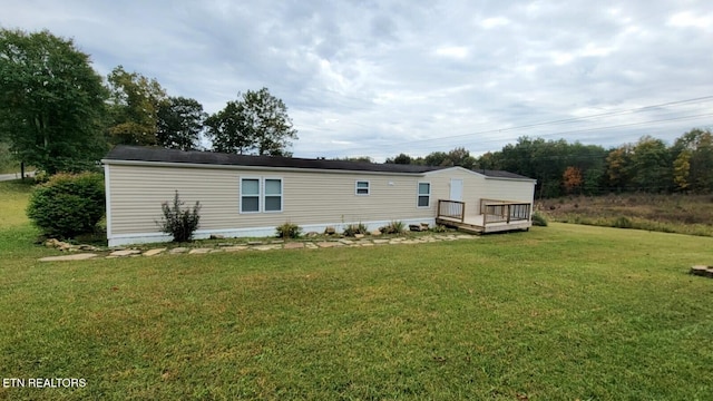 view of front facade with a deck and a front lawn