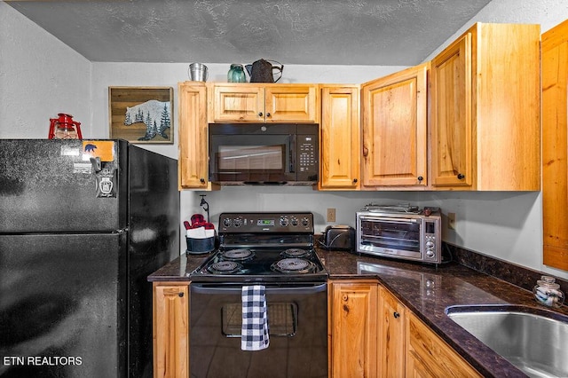 kitchen featuring black appliances, sink, dark stone counters, and a textured ceiling