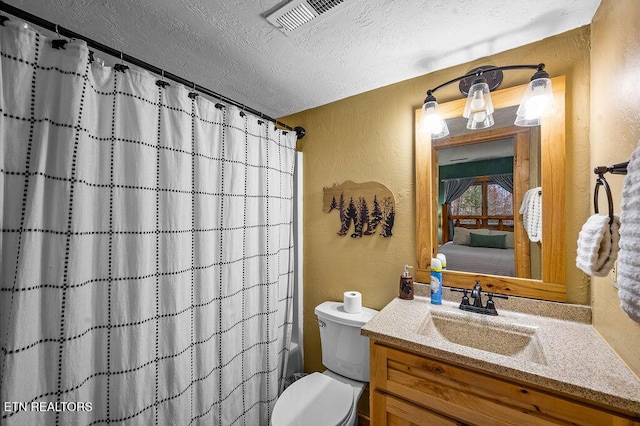 full bathroom featuring shower / tub combo with curtain, vanity, a textured ceiling, and toilet