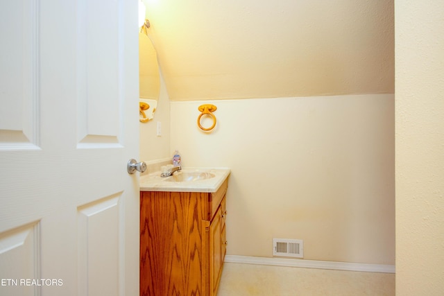 bathroom with lofted ceiling, visible vents, and vanity