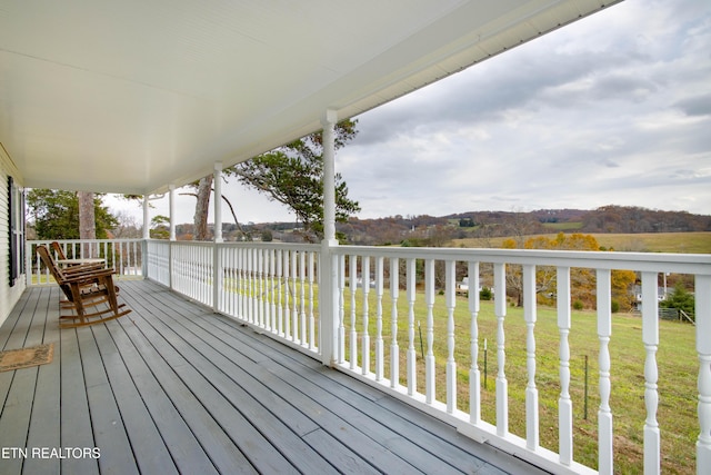 deck featuring a water view and a lawn