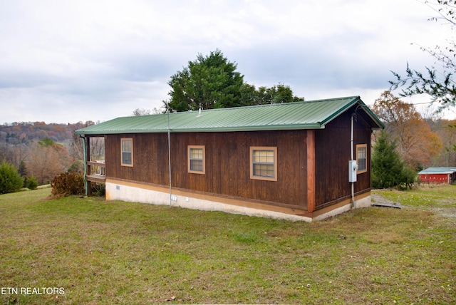 view of property exterior featuring crawl space, metal roof, and a lawn