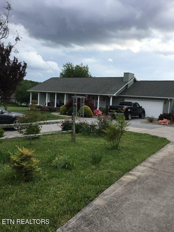 ranch-style home with a garage and a front lawn