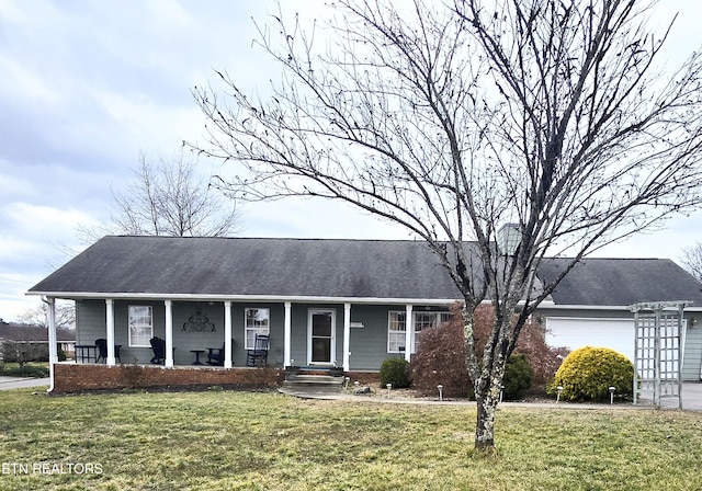 single story home featuring a garage, covered porch, and a front lawn