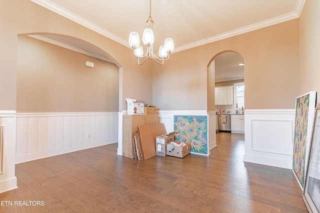 spare room with dark hardwood / wood-style floors, an inviting chandelier, and crown molding