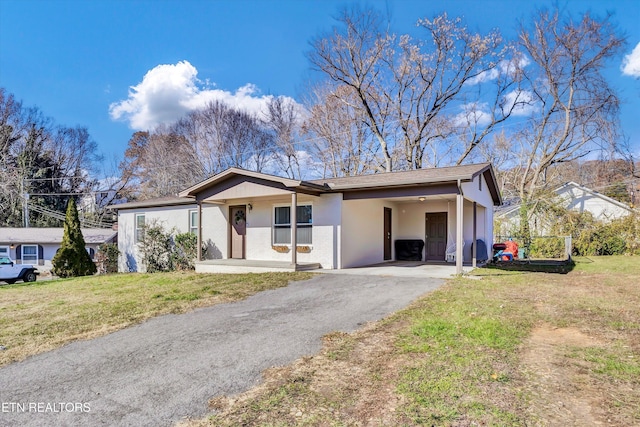 ranch-style home featuring a front yard and a carport