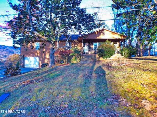 view of front of home featuring covered porch, a garage, and a front yard