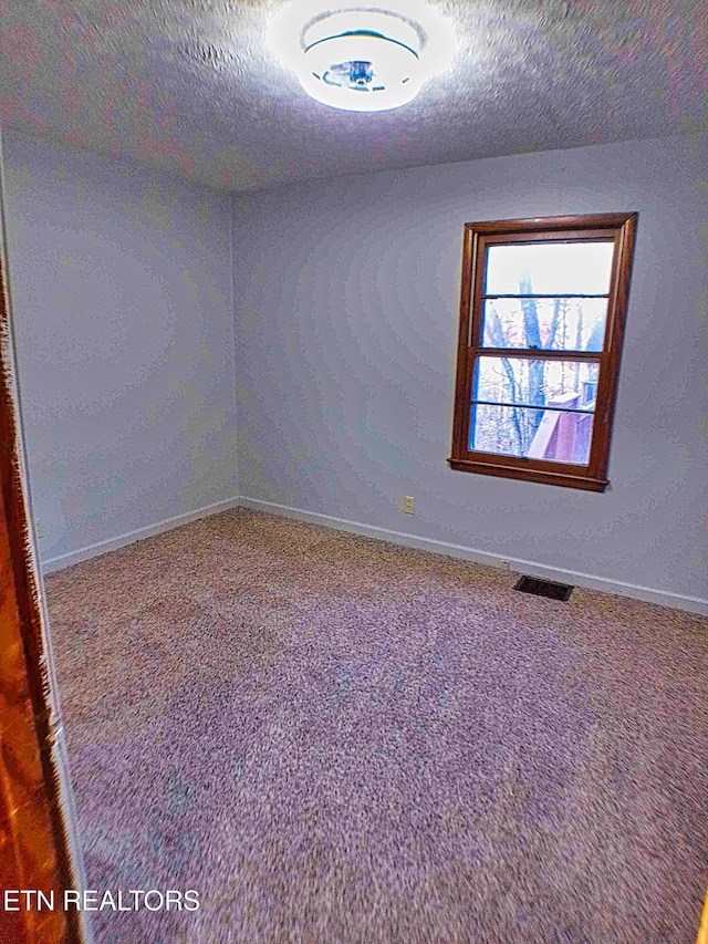 unfurnished room featuring carpet flooring and a textured ceiling