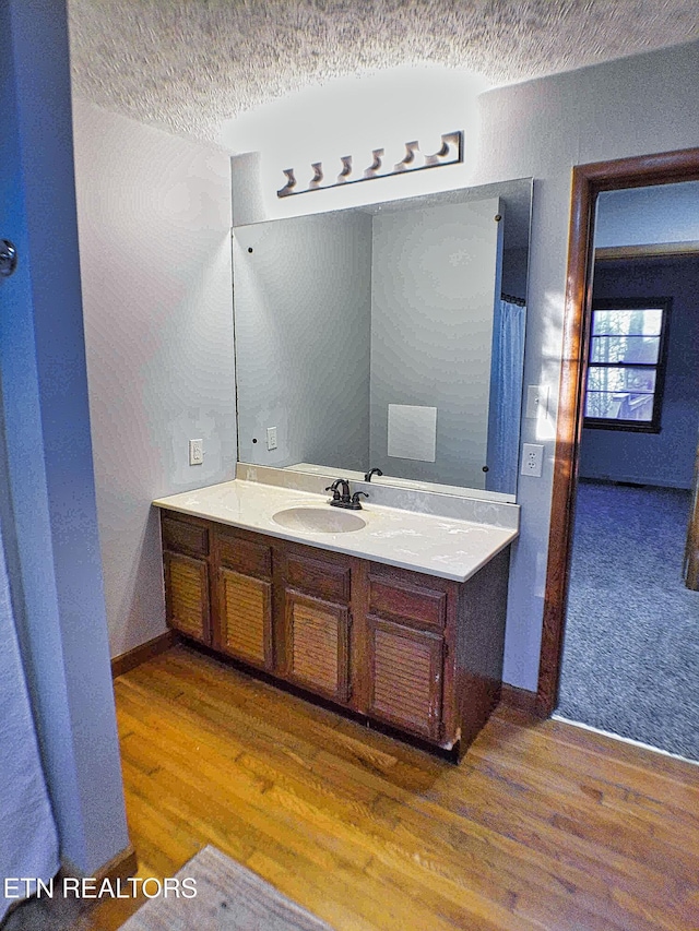 bathroom featuring vanity, a textured ceiling, and hardwood / wood-style flooring