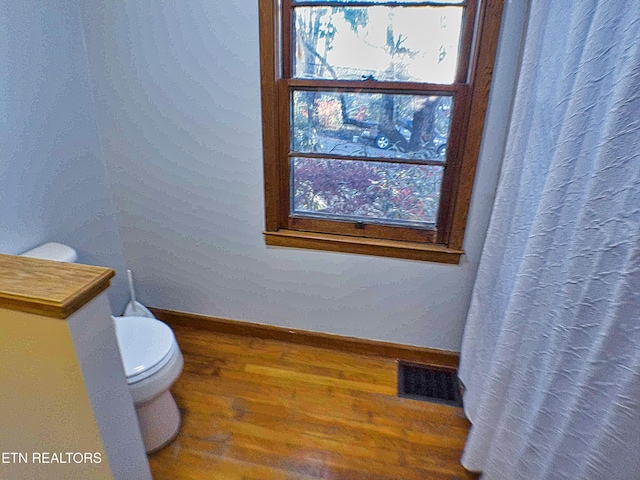 bathroom with toilet and wood-type flooring