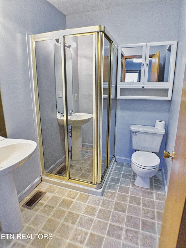 bathroom with a shower with door and toilet