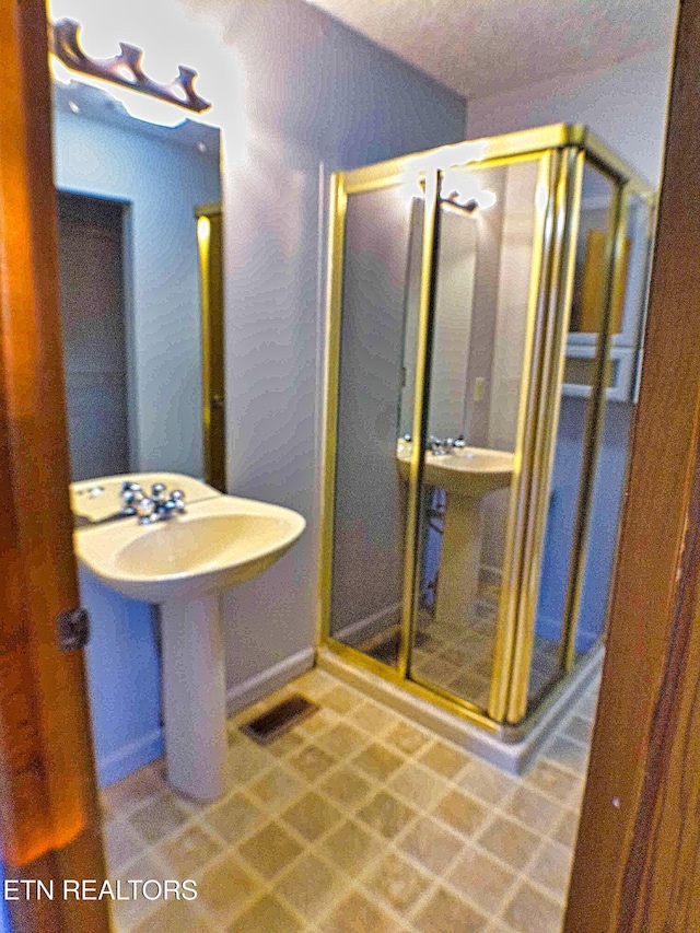 bathroom with sink and an enclosed shower