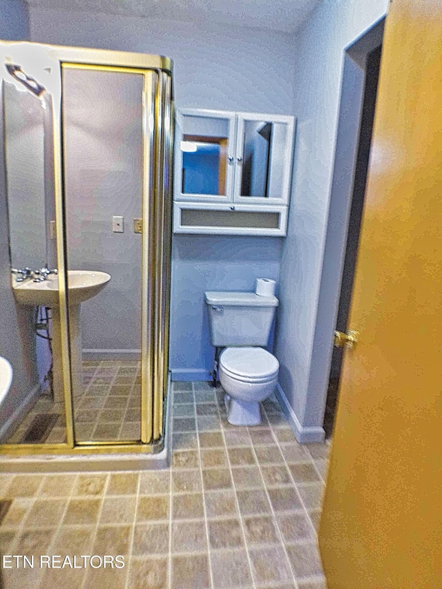 bathroom featuring toilet and a shower with door