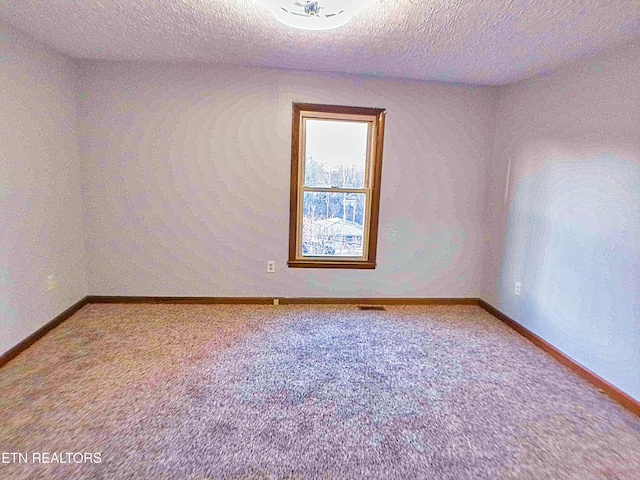 carpeted spare room with a textured ceiling