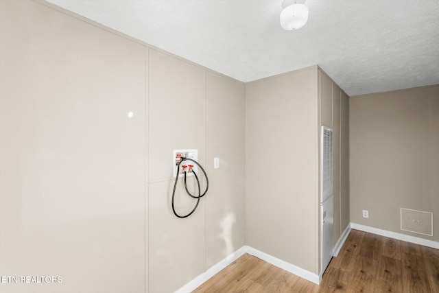 laundry room with hookup for a washing machine, hardwood / wood-style floors, and a textured ceiling